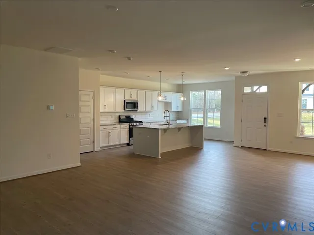 a large kitchen with cabinets and wooden floor