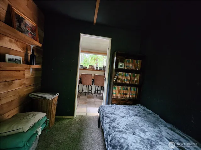 a living room with furniture a bookshelf and a window
