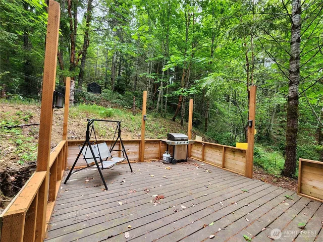 a view of house with deck outdoor seating and trees