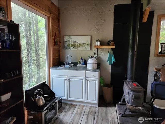 a kitchen with a refrigerator and a stove with wooden floor