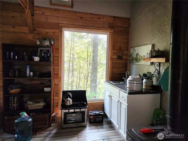 a kitchen with granite countertop a stove and a wooden floor