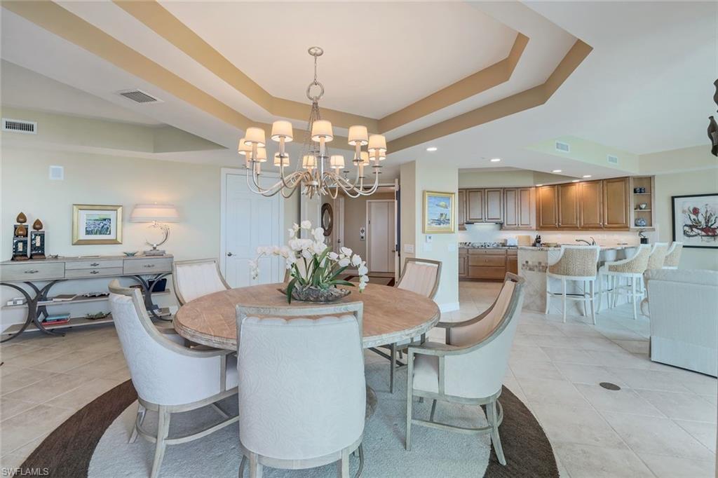 295 Grande Way, Unit 1202 Naples, FL 34110 - Photo 13 of 36 a view of a dining room with furniture and chandelier