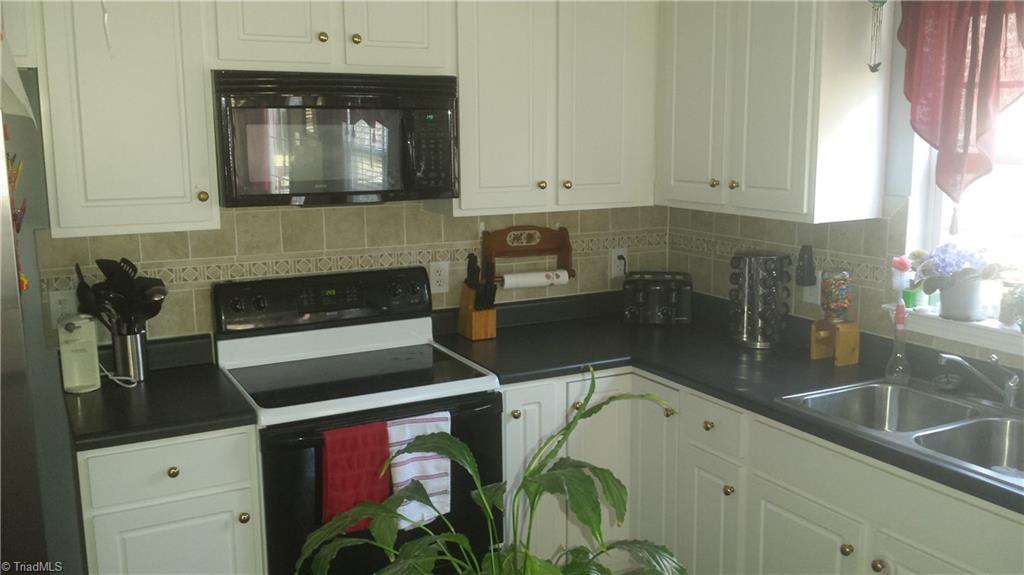 331 Ridgeland Drive High Point, NC 27262 - Photo 6 of 17 Kitchen with ceramic backsplash, black counter top and Stainless Steel appliances.