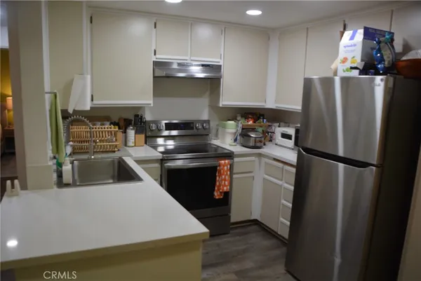 a kitchen with a refrigerator a stove and wooden cabinets
