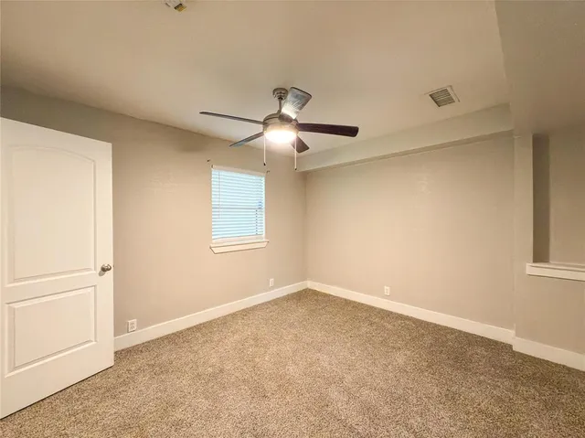 a view of a room with a ceiling fan and a window