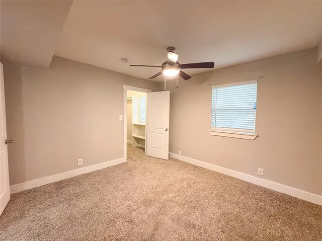 a view of an empty room with a ceiling fan