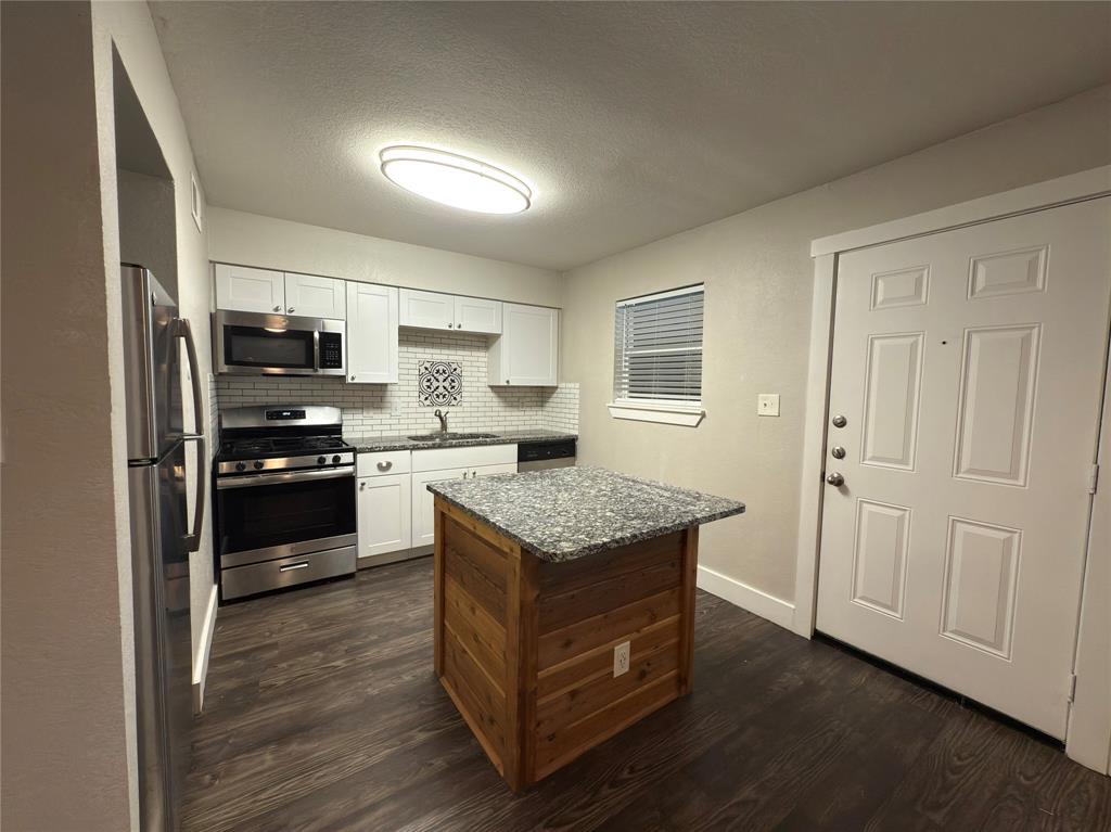 5928 Fletcher Avenue, Unit 16 Fort Worth, TX 76107 - Photo 6 of 20 a kitchen with granite countertop a refrigerator and a stove top oven