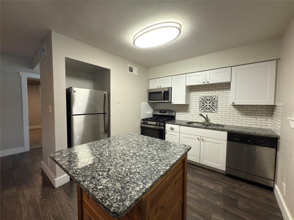 5928 Fletcher Avenue, Unit 16 Fort Worth, TX 76107 - Photo 7 of 20 a kitchen with stainless steel appliances granite countertop a sink dishwasher stove top oven and refrigerator