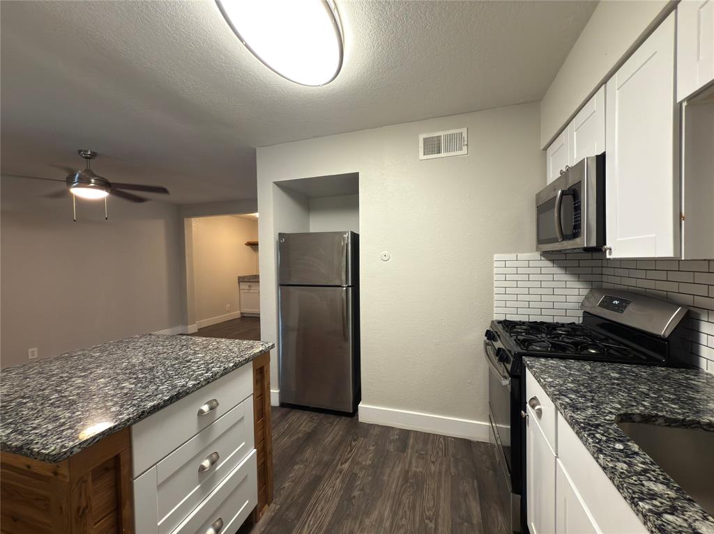5928 Fletcher Avenue, Unit 16 Fort Worth, TX 76107 - Photo 8 of 20 a kitchen with kitchen island granite countertop stainless steel appliances and wooden cabinets