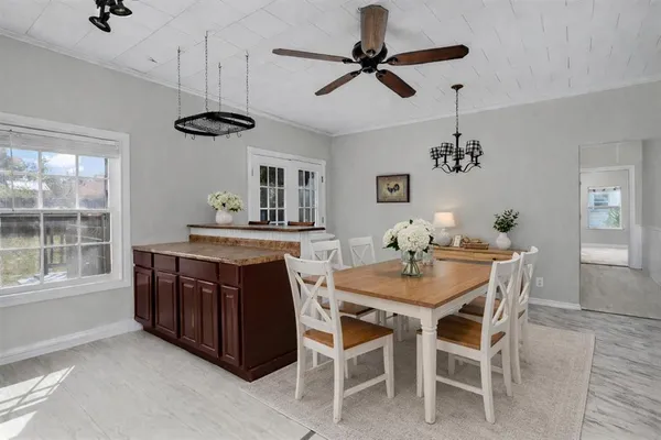 a kitchen with a dining table chairs and a large window