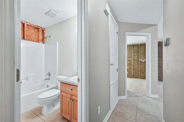 a bathroom with a granite countertop toilet a sink and a mirror