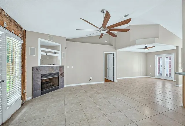 a view of an empty room with a fireplace and a window
