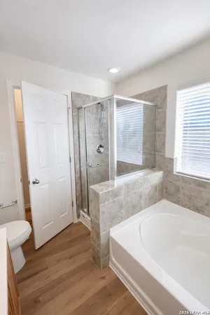 a spacious bathroom with a tub shower and sink