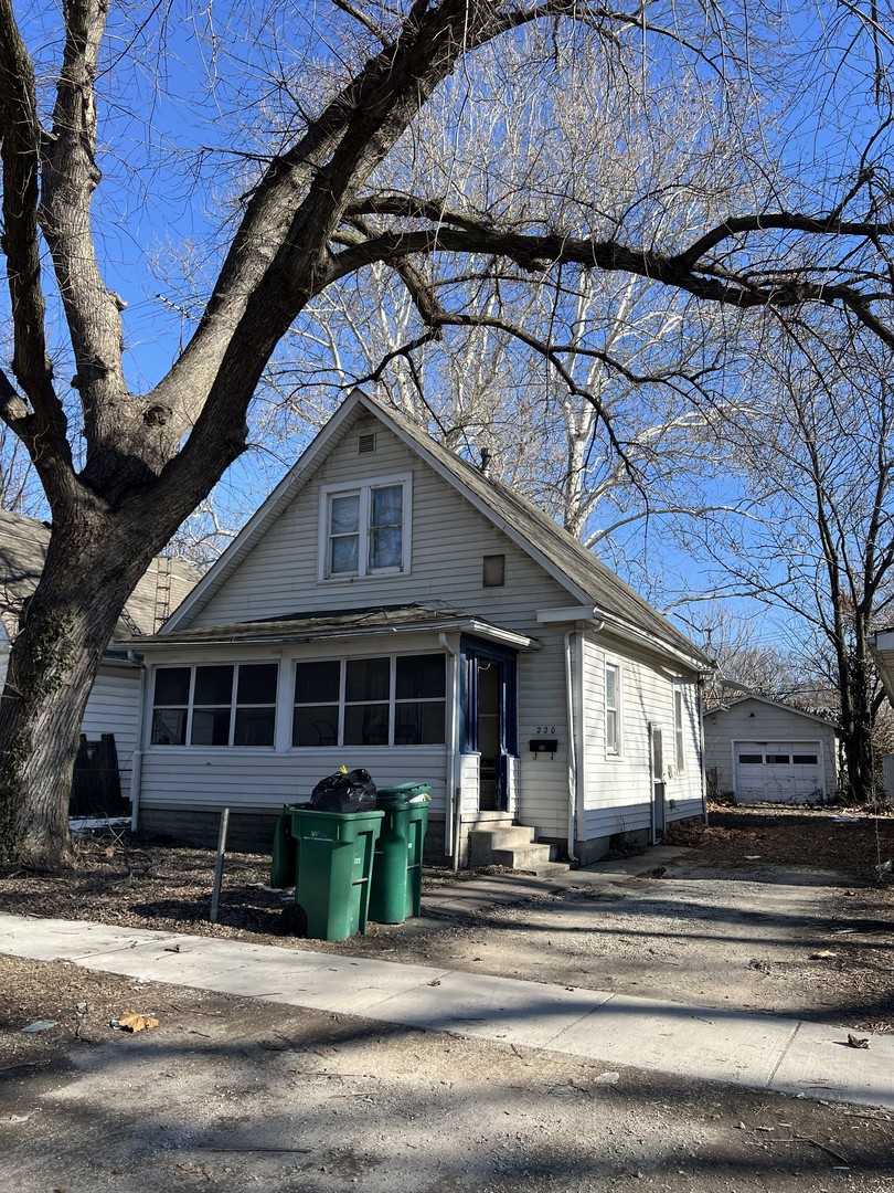 a view of a house with a small yard plants and large tree