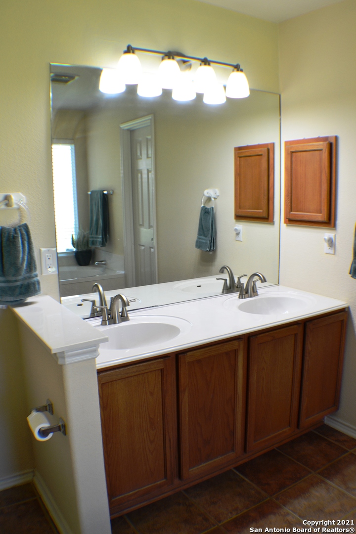 1715 Mountain Brook Schertz, TX 78154 - Photo 32 of 44 a bathroom with a double vanity sink and a mirror