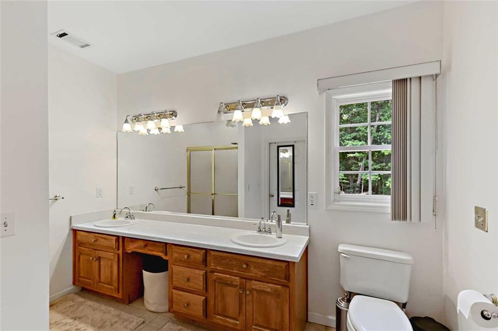 2203 Arbor Hill Road Canton, GA 30115 - Photo 60 of 64 a spacious bathroom with a double vanity sink a large mirror and a toilet