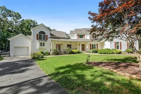 a aerial view of a house next to a big yard and large trees