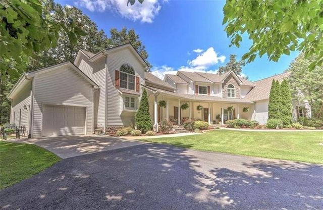 an aerial view of residential house with outdoor space and trees all around
