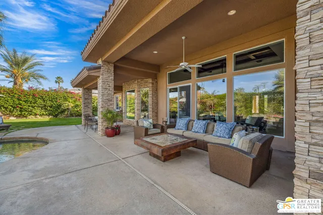 a living room with furniture a fireplace and a floor to ceiling window