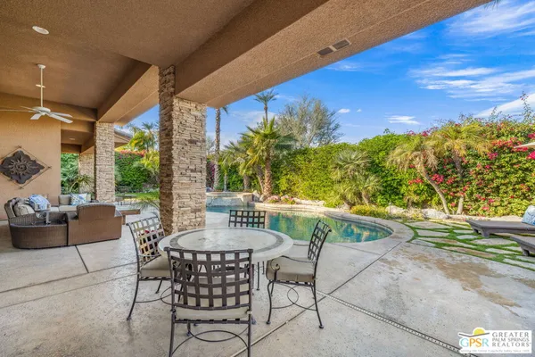 a view of a patio with a table and chairs under an umbrella