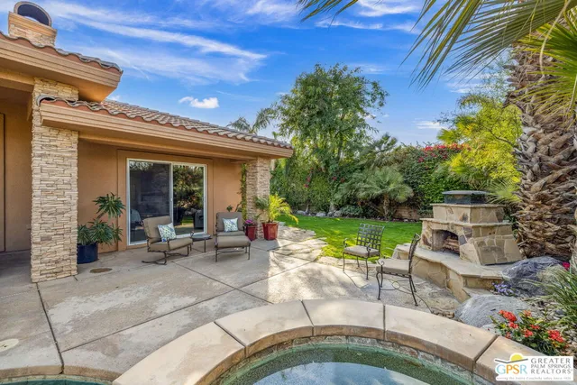 a living room with furniture a fireplace and a floor to ceiling window