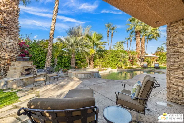 a living room with furniture a fireplace and a floor to ceiling window