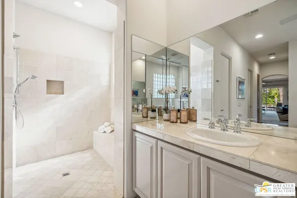 a bathroom with a granite countertop sink a mirror and a shower