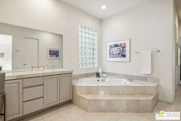 a spacious bedroom with a bed and a potted plant