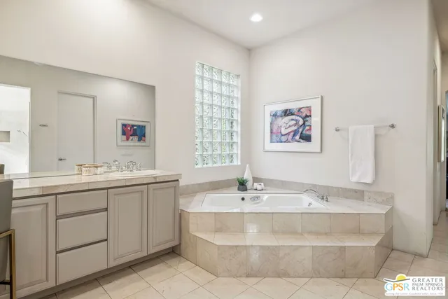 a spacious bedroom with a bed and a potted plant