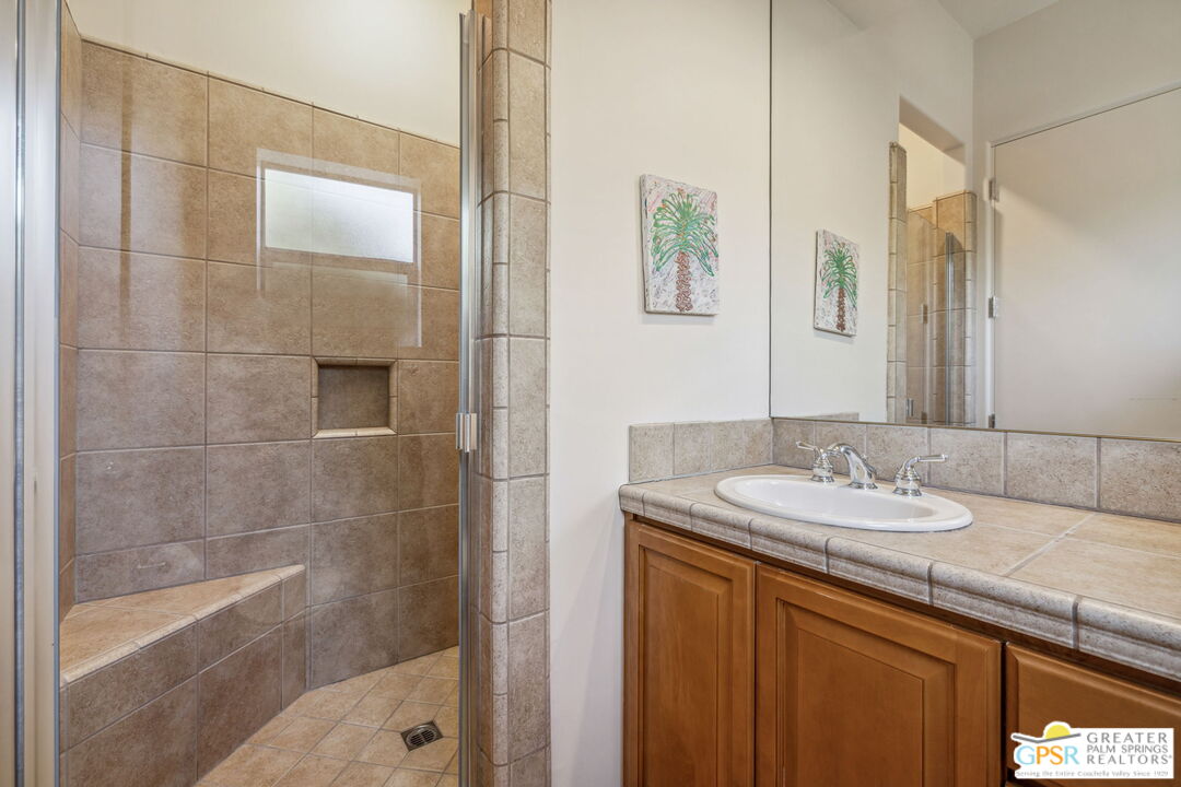 2 Varsity Circle Rancho Mirage, CA 92270 - Photo 47 of 65 a bathroom with a granite countertop sink a mirror and a bathtub