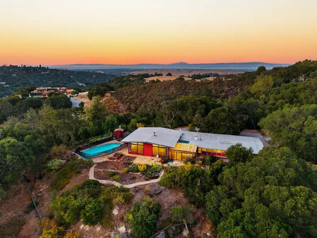 an aerial view of residential houses with outdoor space and swimming pool