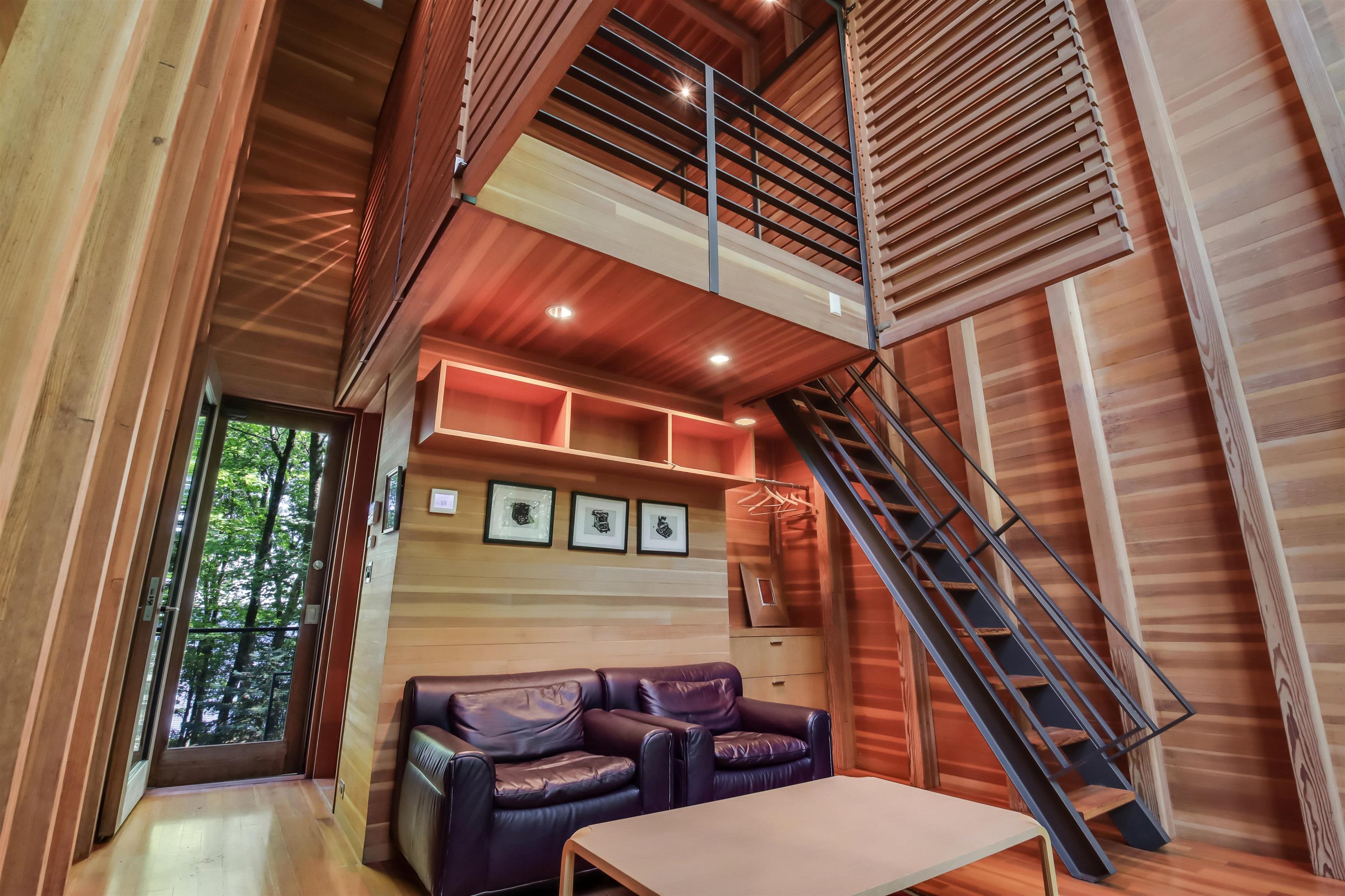 15773 Lake Shore Road Hayward, WI 54843 - Photo 41 of 41 Unfurnished living room with a high ceiling, hardwood / wood-style floors, and wood walls