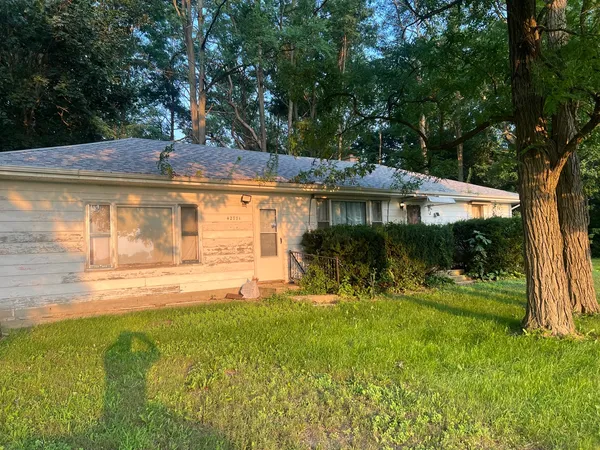 a view of a house with backyard and sitting area