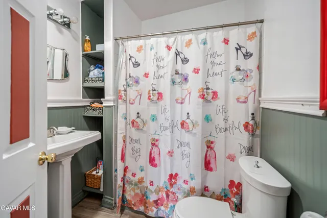 a bathroom with a sink toilet and shower curtain