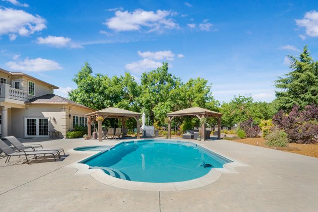 a view of a patio with table and chairs potted plants with floor to ceiling window