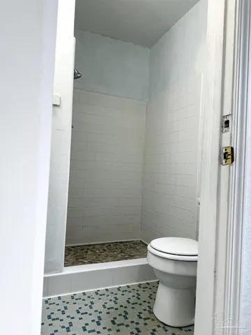 a bathroom with a toilet and a shower