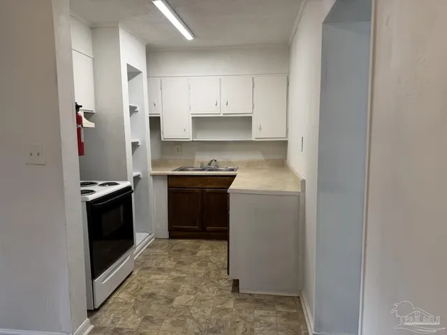a kitchen with a stove top oven sink and cabinets