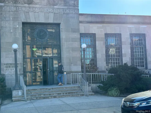 a view of a brick house with a bench next to a yard