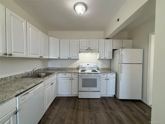 a kitchen with granite countertop cabinets appliances and a sink