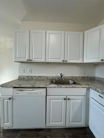 a kitchen with granite countertop white cabinets and a stainless steel appliances