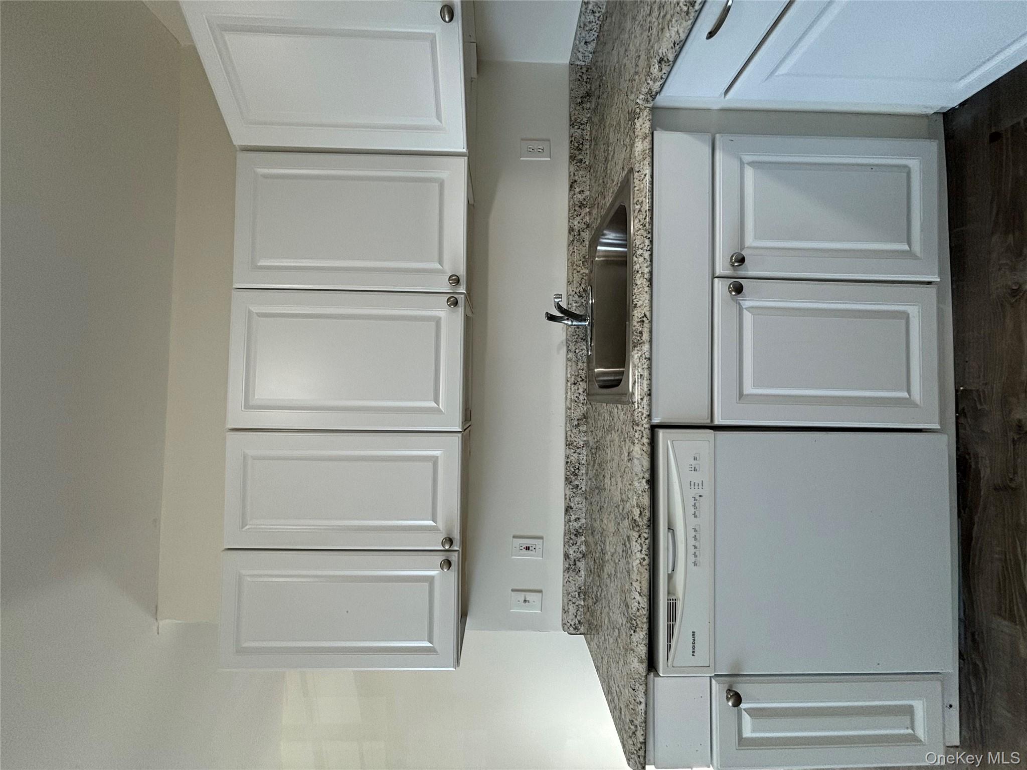 90 East Main Street, Unit 2 Patchogue, NY 11772 - Photo 6 of 14 a kitchen with granite countertop white cabinets and a stainless steel appliances