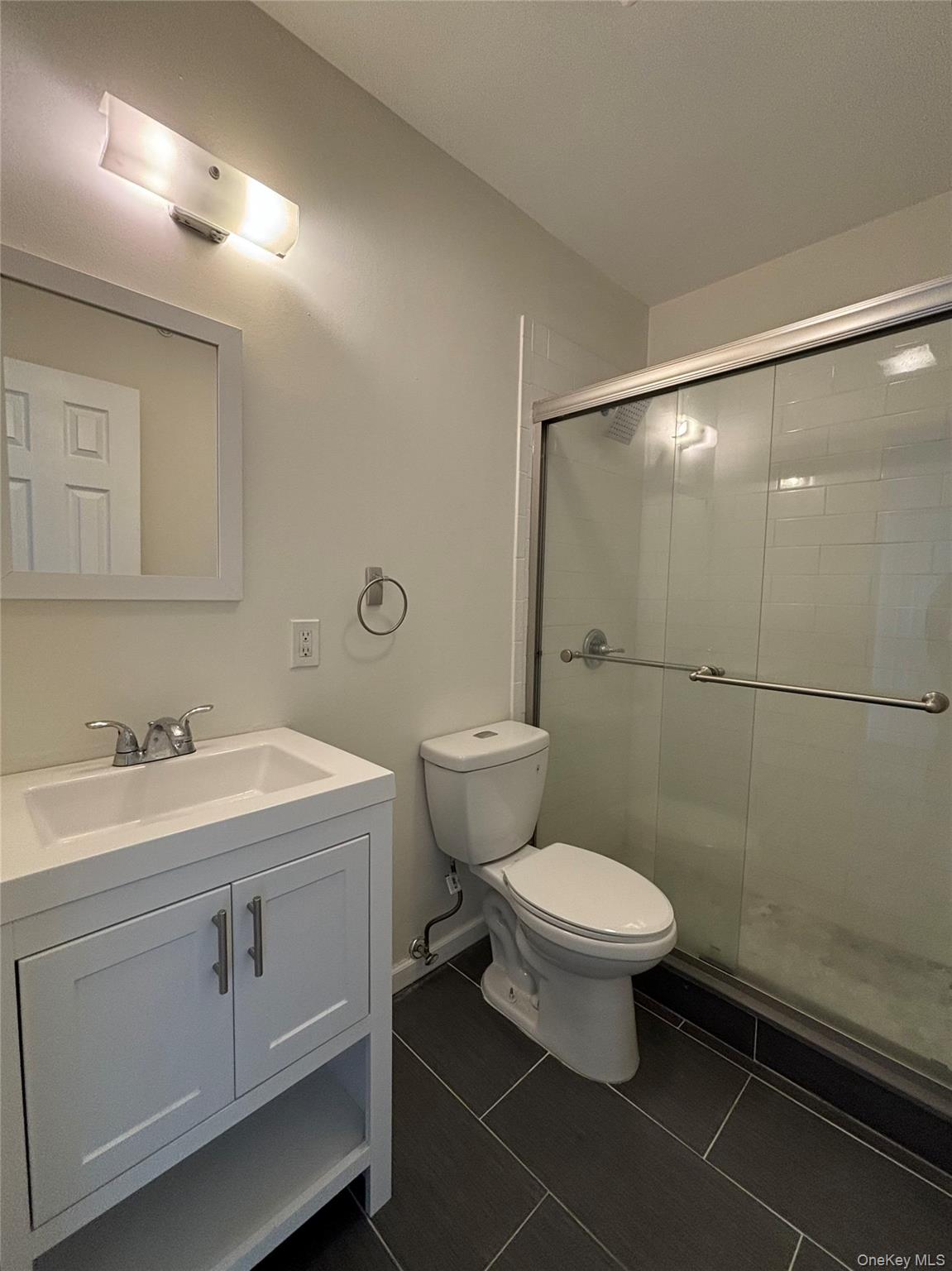 90 East Main Street, Unit 2 Patchogue, NY 11772 - Photo 7 of 14 a bathroom with a toilet sink and mirror