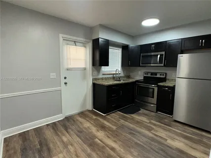 a kitchen with a refrigerator and a stove top oven