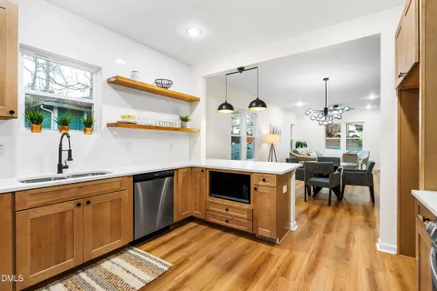 a kitchen with wooden floors and white cabinets