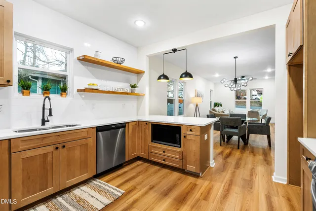 a kitchen with wooden floors and white cabinets