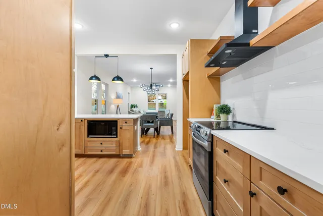 a kitchen with stainless steel appliances granite countertop a lot of counter space and wooden floors