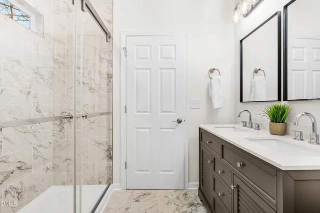 a bathroom with a granite countertop sink a mirror and a shower