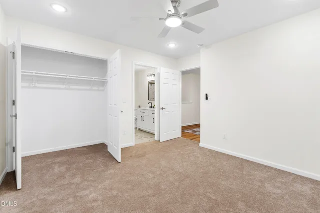 an empty room with a ceiling fan and closet area