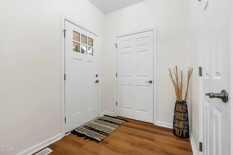 a view of an empty room with wooden floor and closet