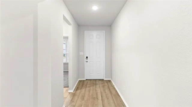a view of a hallway with wooden floor